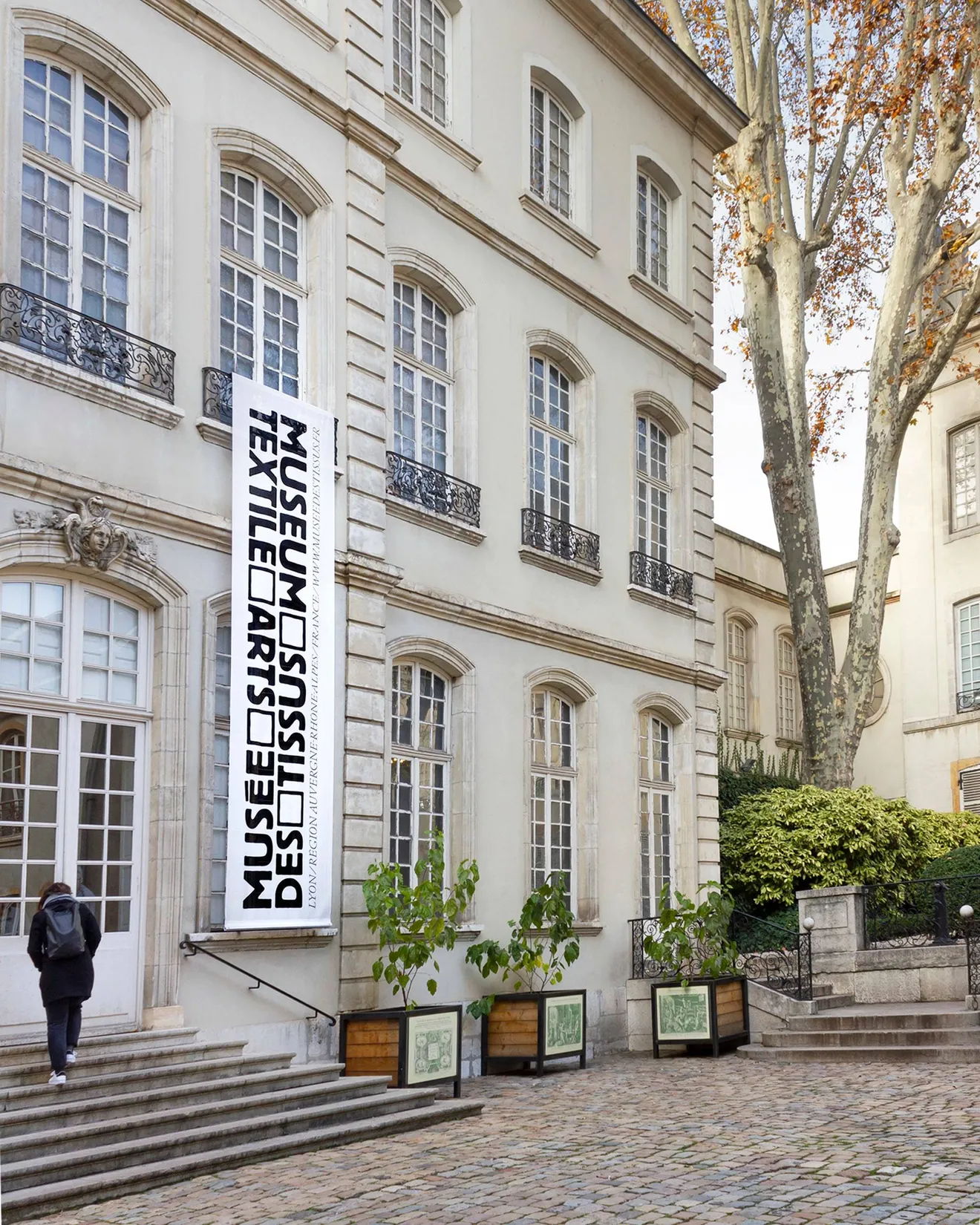 Façade du Musée des Tissus de Lyon avec bannières signalétiques verticales — conception de signalétique extérieure pour musée patrimonial, graphiste freelance Toulouse, Occitanie